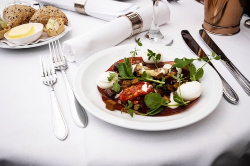 Restaurant-style cruise ship dining with a beautifully presented meal served at an elegant table.
