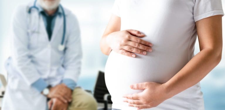 Pregnant woman attending a healthcare appointment with a doctor during pregnancy and fertility care.
